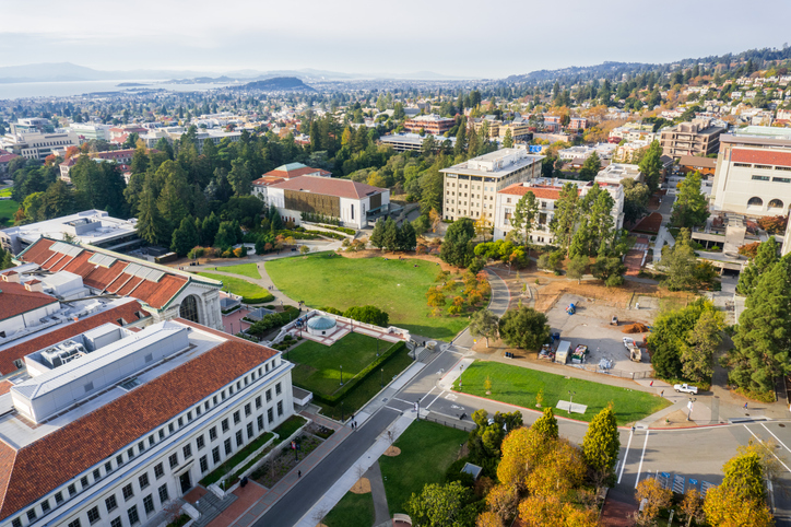 Aerial view of buildings in University of California, Berkeley campus on a sunny autumn day, view towards Richmond and the San Francisco bay shoreline in the background, California