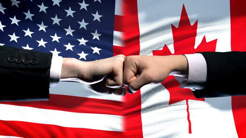 fist pump in front of US flag and Canadian flag