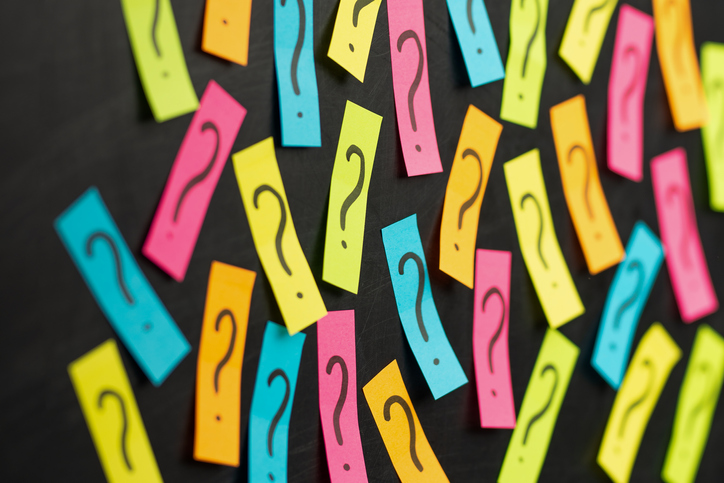Question marks on post-it notes on blackboard